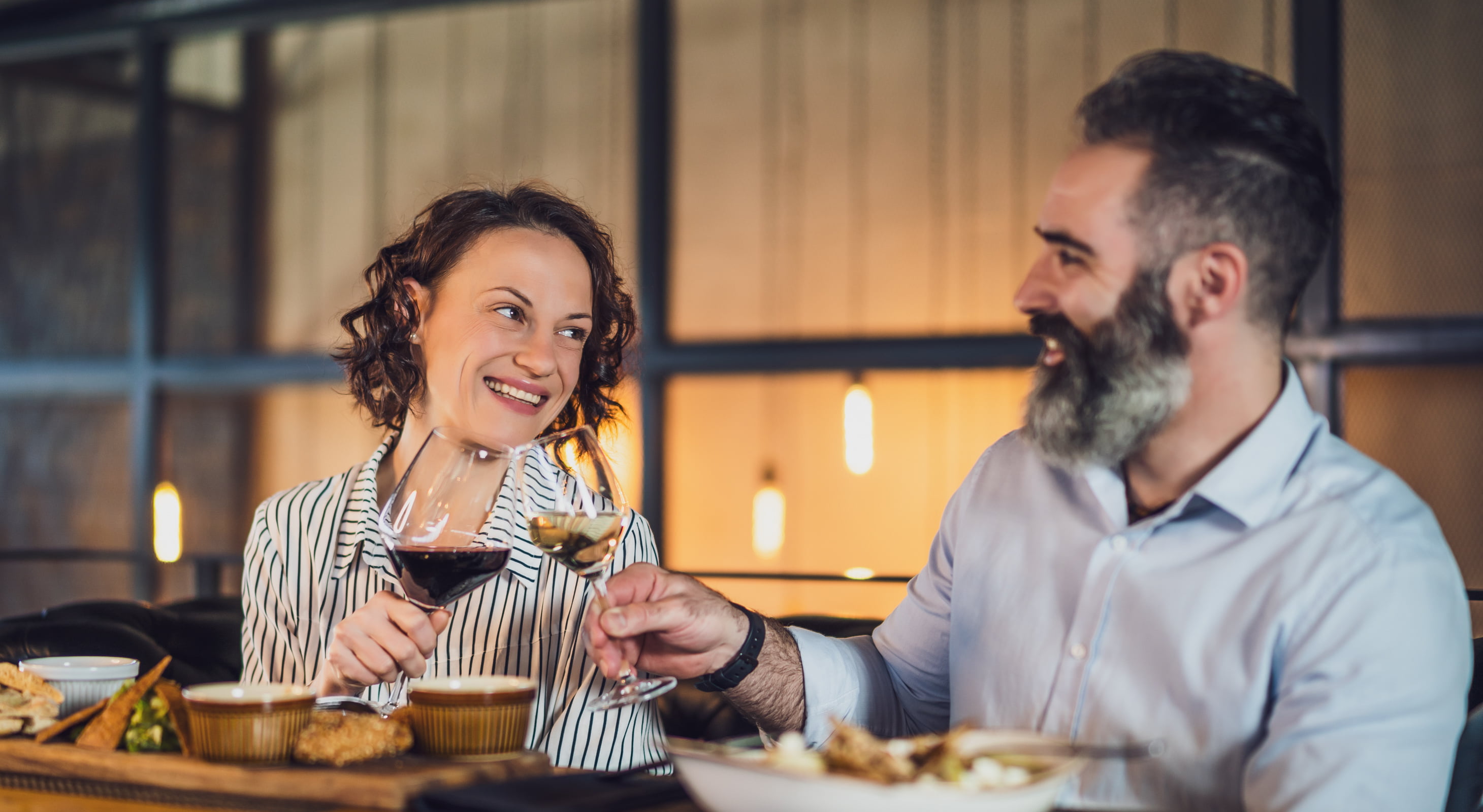 Couple celebrating with wine over dinner