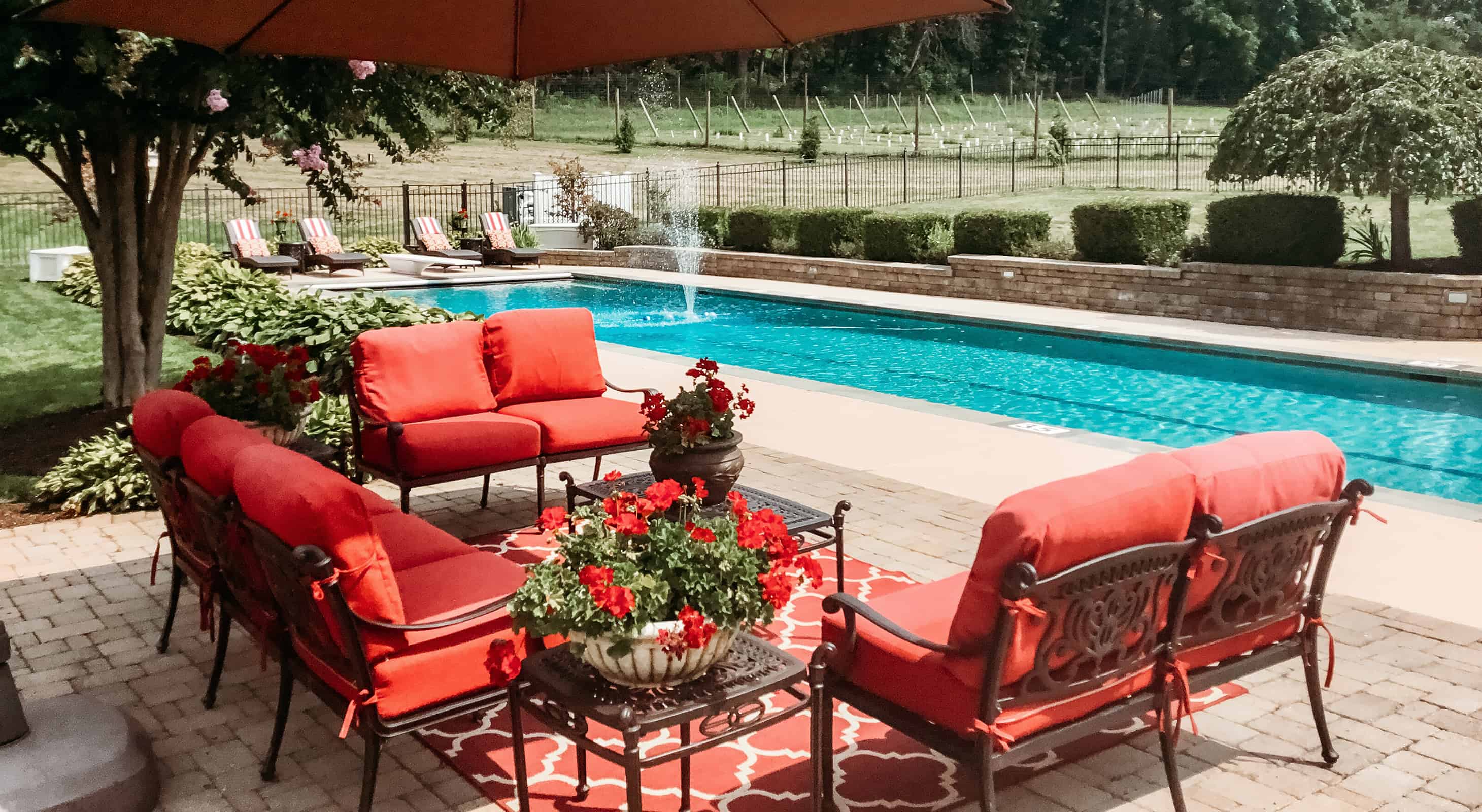 Seating area with comfortable red cushions by the pool